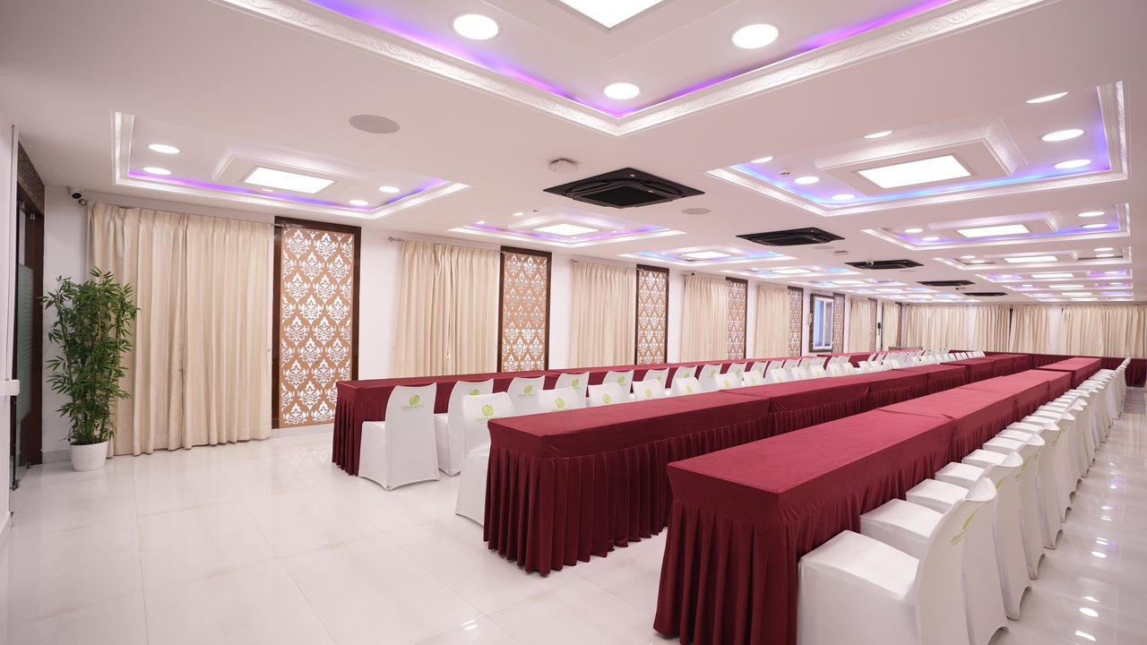Dining hall with long tables laid in maroon and white